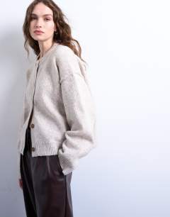 Model wearing Knitted exposed seam relaxed cardigan in oat