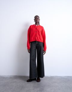 Model wearing Knitted exposed seam relaxed cardigan in red