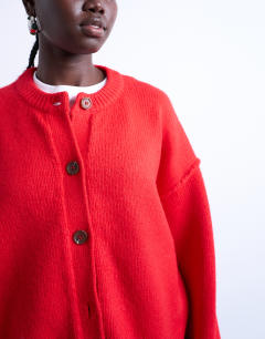 Model wearing Knitted exposed seam relaxed cardigan in red