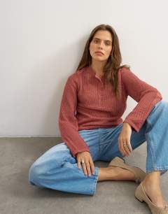 Model wearing Knitted fine gauge henley top in rust red