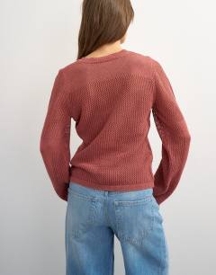 Model wearing Knitted fine gauge henley top in rust red
