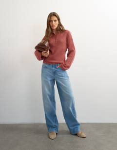 Model wearing Knitted fine gauge henley top in rust red