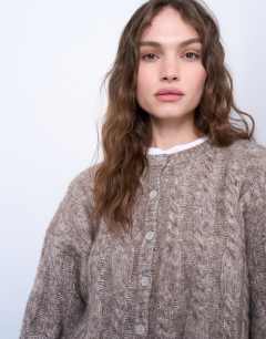 Model wearing Knitted fluffy cable cardigan in oat
