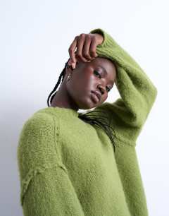 Model wearing Knitted fluffy exposed seam easy jumper in green
