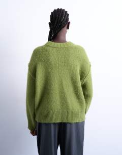 Model wearing Knitted fluffy exposed seam easy jumper in green