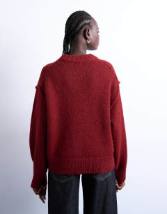 Model wearing Knitted fluffy exposed seam easy jumper in red