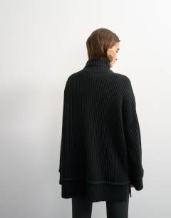 Model wearing Knitted high neck roll seam detail oversized jumper with wool in black