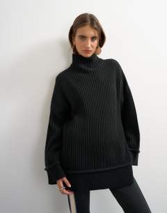 Model wearing Knitted high neck roll seam detail oversized jumper with wool in black