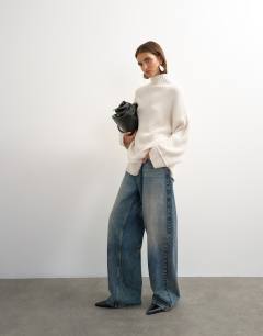 Model wearing Knitted high neck roll seam detail oversized jumper with wool in ivory