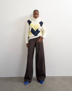 Model wearing Knitted high roll neck wool blend intarsia chevron jumper in ivory