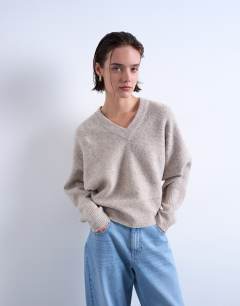 Model wearing Knitted high v horizontal stitch jumper in oat