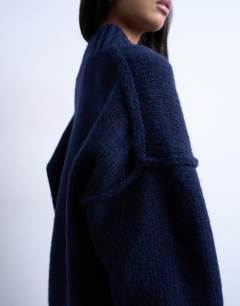 Model wearing Knitted high V-neck mini oversized dress in Navy