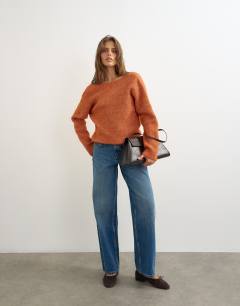 Model wearing Knitted knot back detail jumper with wool in terracotta