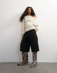 Model wearing Knitted long sleeve fallen shoulder jumper with wool in latte