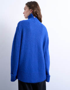 Model wearing Knitted oversized funnel neck longline jumper with neck detail