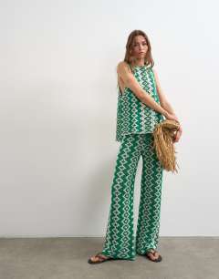 Model wearing Knitted patterned crochet look co-ord shirt in green and white