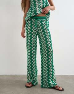 Model wearing Knitted patterned crochet look co-ord trouser in green and white
