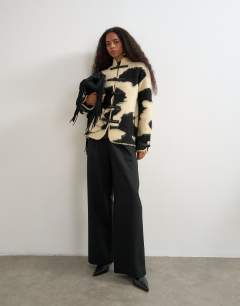 Model wearing Knitted patterned frogging detail jacket in black and white