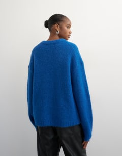 Model wearing Knitted premium alpaca blend frogging detail cardigan in blue