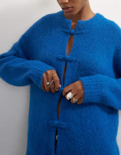 Model wearing Knitted premium alpaca blend frogging detail cardigan in blue