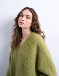 Model wearing Knitted premium alpaca  v neck jumper in avacado