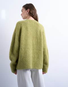 Model wearing Knitted premium alpaca  v neck jumper in avacado
