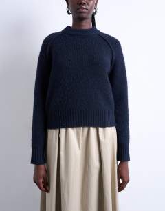 Model wearing Knitted raglan exposed seam jumper in navy