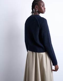 Model wearing Knitted raglan exposed seam jumper in navy