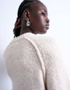 Model wearing Knitted raglan exposed seam jumper in oat