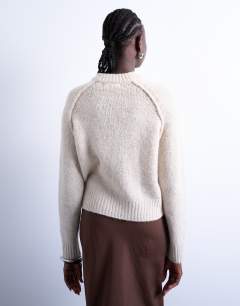 Model wearing Knitted raglan exposed seam jumper in oat
