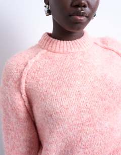 Model wearing Knitted raglan exposed seam jumper in pink