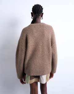 Model wearing Knitted ribbed balloon sleeve jumper in brown