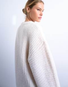 Model wearing Knitted ribbed balloon sleeve jumper in ivory