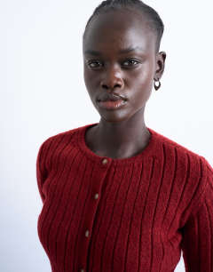 Model wearing Knitted ribbed button crew cardigan in red