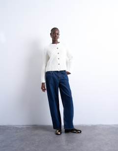 Model wearing Knitted ribbed crew relaxed button cardigan in white
