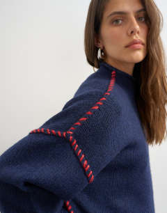 Model wearing Knitted roll edge blanket stitch jumper in navy