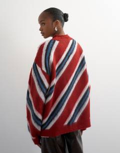 Model wearing Knitted roll edge stripe jumper in red multi