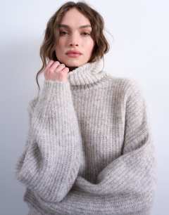 Model wearing Knitted roll neck mini dress in oat
