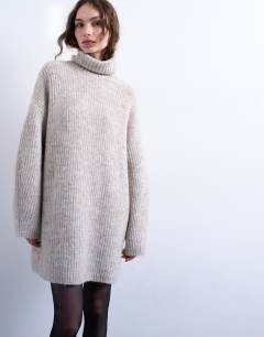 Model wearing Knitted roll neck mini dress in oat