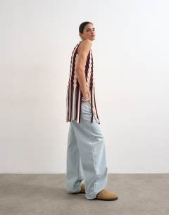 Model wearing Knitted sleeveless longline knit top with tassel fringe hem in burgundy