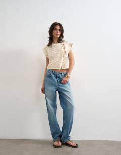 Model wearing Knitted sleeveless mandarin collar front tie wrap tank in ecru