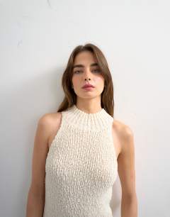 Model wearing Knitted sleeveless textured grown on vest in ivory