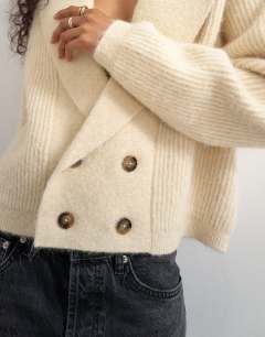 Model wearing Knitted slouchy button front shawl collared cardigan in latte