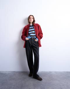 Model wearing Knitted stripe polo in blue and chocolate