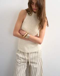 Model wearing Knitted textured grown on vest in ivory