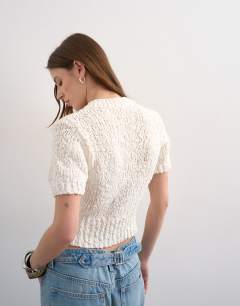 Model wearing Knitted textured short sleeve cardigan in ivory