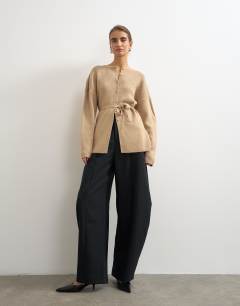 Model wearing Knitted tie back all needle cardigan in oat