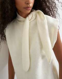 Model wearing Knitted tie neck top in ivory 