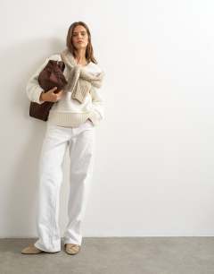 Model wearing Knitted v neck slouchy roll seam detail jumper with wool in ivory