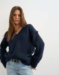 Model wearing Knitted v neck slouchy roll seam detail jumper with wool in midnight